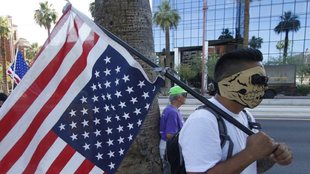 A man holds the US flag upside down as a sign of protest against the bill.