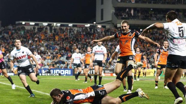 Mitch Brown of the Tigers crosses the line to score the winning try.
