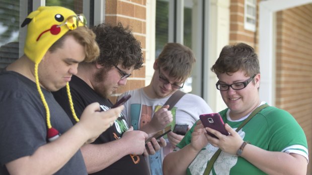 Chase Brown, Keith Harrell, Christopher Van Avery and Alex Hicks play "Pokemon Go" at Gulf Coast State College in Panama City, Florida.