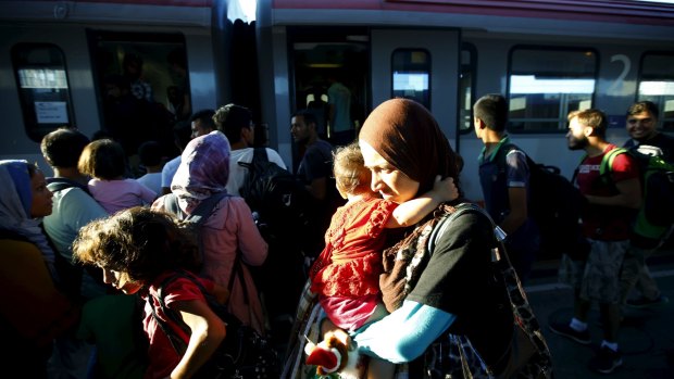 Migrants, many fleeing from warzones, move through Vienna's main railway station on Monday.