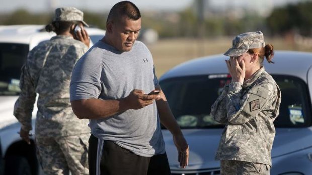 Soldiers wait outside the Fort Hood military base in Texas in 2009 after a gunman killed 12 people and injured 31 in a shooting. Major Nidal Hasan is standing trial over the shootings.