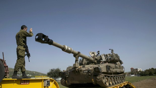 An Israeli soldier directs a mobile artillery unit in the Druze village of Buqata in the Golan Heights on Monday.
