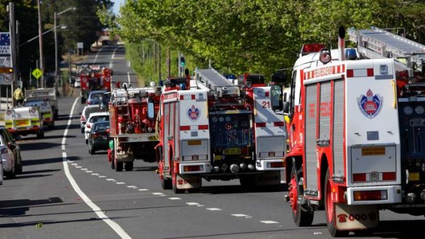 Undeterred: Tourist cars drive among firetrucks towards the Blue Mountains in the hope of catching a glimpse of the action.