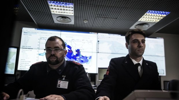 Italian coast guard officers use monitors to track ships navigating the area where the boat believed to be crowded with perhaps as many as 700 migrants capsized in the waters north of Libya.