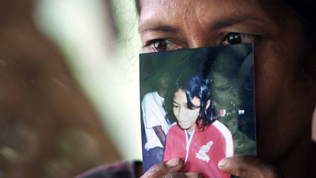 In this 2001 photo, Madalena Soares holds a photo of her 12-year-old daughter, Cesaltina, taken from her during the 1999 conflict and placed in a Java orphanage.