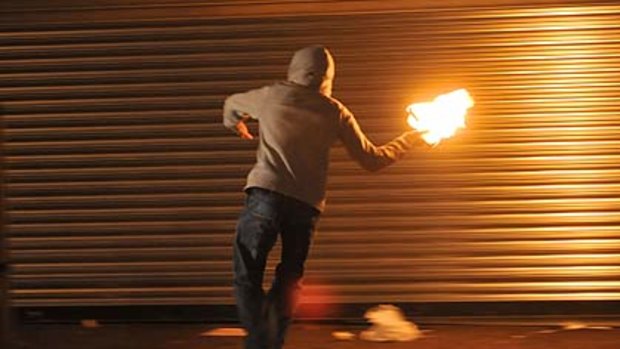 A masked nationalist throws a Molotov cocktail at the police in Belfast.