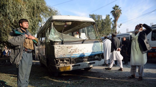 An Afghan security policeman stands guard near a damaged bus after a suicide attack in Nangarhar province east of Kabul, on Thursday.