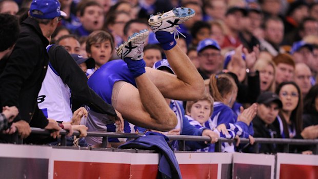 North's Drew Petrie ends up in the crowd after taking a mark at Etihad Stadium.