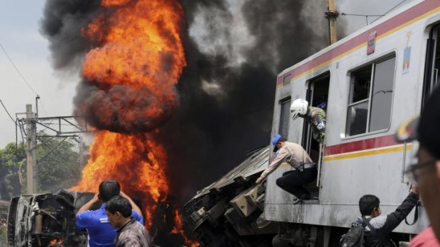 Smoke and flames billow from a fire after a commuter train collided with a truck hauling fuel on the outskirts of Jakarta.