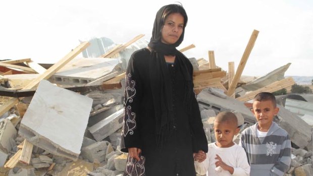 Rifa al-Oqbi and her two sons stand amid the rubble that was their home in the village of al-Qrain, in Israel’s southern Negev Desert.