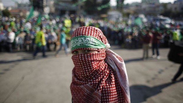 A masked Palestinian boy takes part in a rally celebrating what organisers say was a victory by Palestinians in Gaza over Israel following a ceasefire, in the West Bank city of Ramallah.