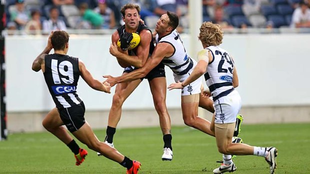 This one is mine... Collingwood's Travis Cloke makes sure that the ball stays within his grasp as Geelong's Harry Taylor challenges.