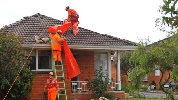 Emergency workers at a storm-damaged house on Birdwood Avenue, Aspendale.