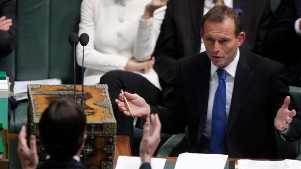 Climate Change Minister Greg Combet and Opposition Leader Tony Abbott gesture to each other during Question Time on Tuesday.