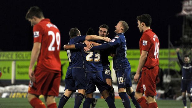 Red faced: Oldham United players celebrate their upset over Liverpool in the FA Cup.