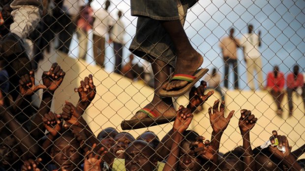 A crowd of South Sudanese soccer fans cram against a fence in Juba to watch their country's first international football game in July 2011.