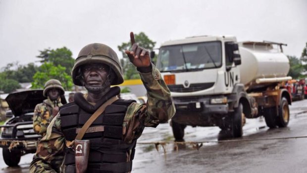 A Liberian soldiers stops people at a security checkpoint set up to clamp down on people traveling due to the Ebola virus, on the outskirts of Monrovia.