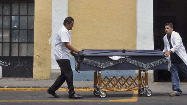 Forensic workers remove one of the decapitated bodies from a morgue in Guadalajara, Mexico. Police found the dismembered bodies of 15 people dumped near Mexico’s second city earlier this month.