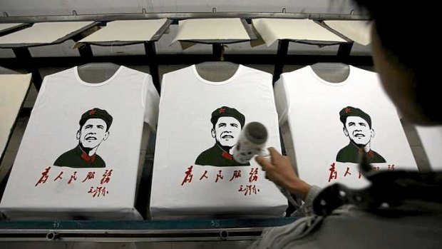 A worker dries shirts bearing an image of US President Barack Obama's face over that of China's late Chairman Mao Zedong at a shirt printing factory located on the outskirts of Beijing.