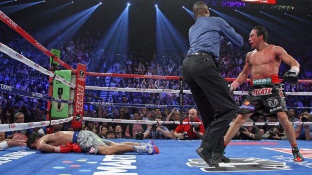 Juan Manuel Marquez  stares down at Manny Pacquiao who lies face down on the mat after being knocked out in their 2012 bout.