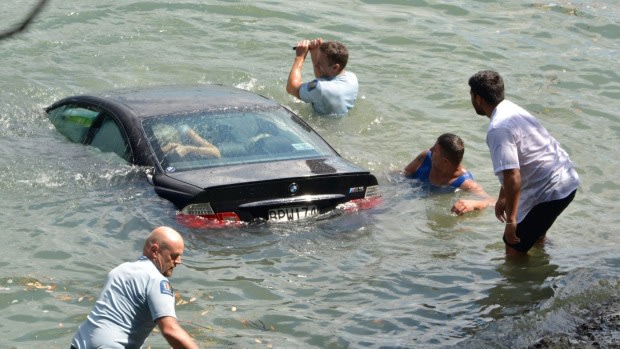 Police make a desperate bid to reach the woman in her sinking car.