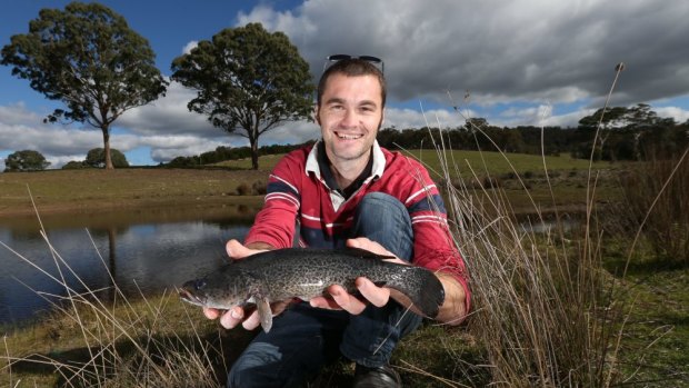 Plate-sized: John Breen with a cod that was bred from stock that live in the dam behind him.