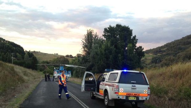 Single vehicle car crash ...  rescuers and a helicopter at the scene.