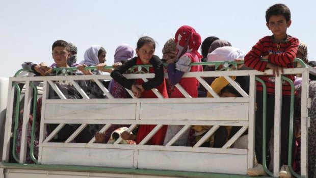 Yazidi families, who fled from the town of Sinjar, arrive in Dohuk.