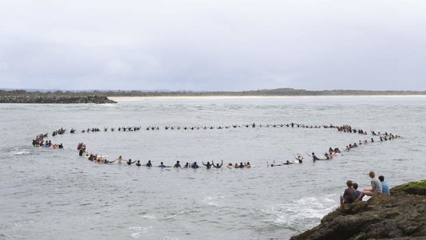 Paying tribute: Friends of shark attack victim Zac Young form a circle off Port Macquarie's Town beach to remember him.