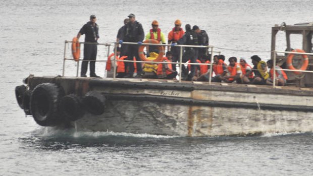 Asylum seekers rescued last month are taken to shore.