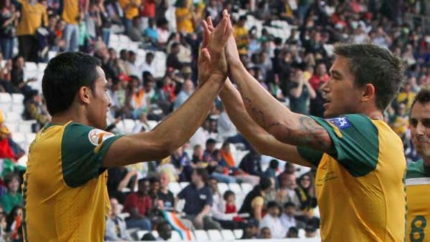 Tim Cahill celebrates with Harry Kewell after scoring against India.