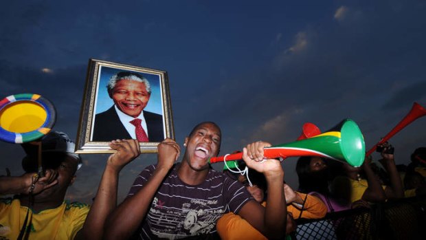 Supporters bearing a photograph of Nelson Mandela watch the opening game of the 2010 Soccer World Cup in South Africa.