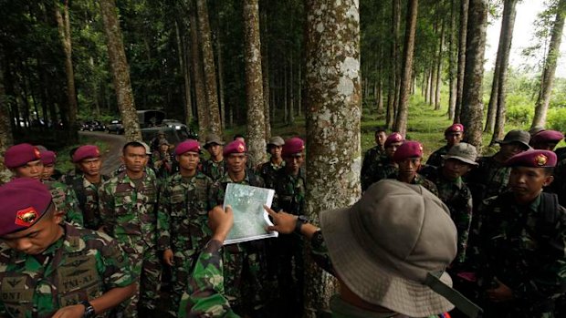 Search ... an Indonesian marine soldier holds a map to indicate the location of the plane crash, during a briefing at Halimun National Park near Bogor.