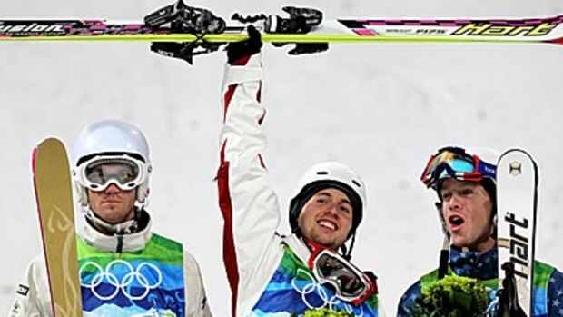 Australia's Dale Begg-Smith looks less than impressed with his silver medal, while first placegetter Alexandre Bilodeau of Canada and third Bryon Wilson of the United States celebrate after the Freestyle Skiing Men's Moguls.