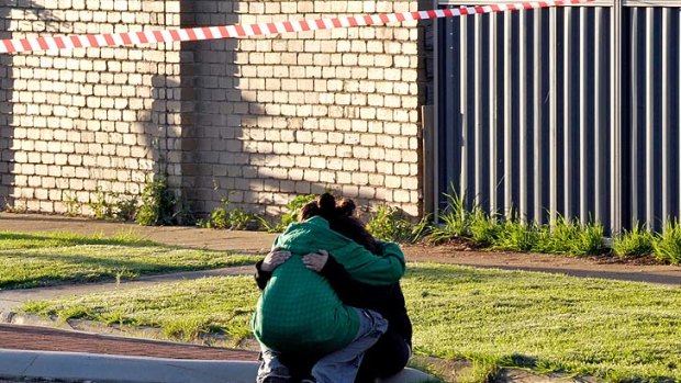 Grief ... Emotions are run high outside the burned house in Melton South, where a man has lost his life.