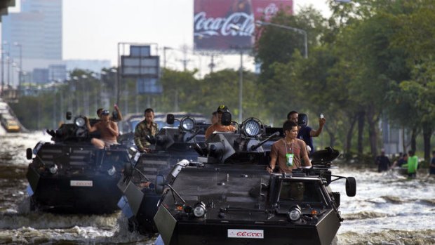 Thai military plow through the water into the flood zone in armored personnel carriers in Bangkok.