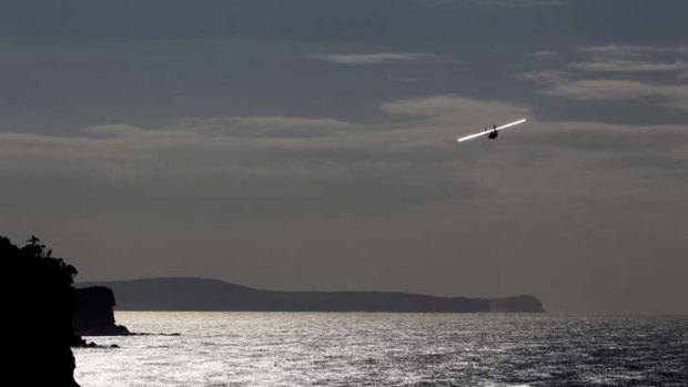 Depth of feeling .... a seaplane conducts a fly-past yesterday to symbolise an air search the day after a deadly attack on Sydney Harbour.