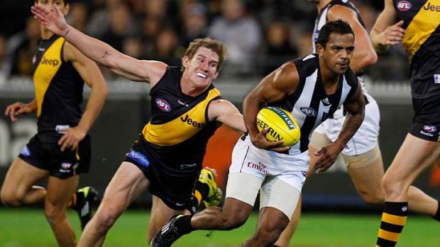 Catch me if you can: Magpies defender Leon Davis escapes the desperate cluches of Tiger Matt White.