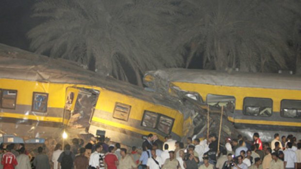 Scene of chaos ... bystanders gather at the scene of the crash 40 kilometres south of Cairo. Passengers were trapped in the mangled wreckage of the two trains.