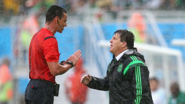 Another howler ... Referee Wilmar Roldan speaks to head coach Miguel Herrera of Mexico in the first half after one of two disallowed goals.
