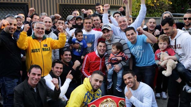 Loosening his belt ... Billy Dib, front right, celebrates his win last week against Jorge Lacierva at a family barbecue yesterday in Greenacre.