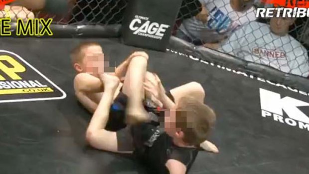 Two children fight inside a cage.