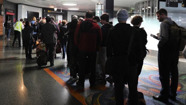Passengers queue in darkness as workers scramble to restore power to Melbourne Airport.