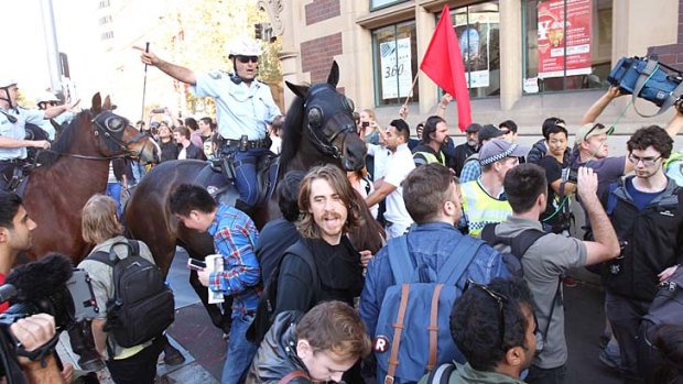 Stand-off: a police officer on a horse directs protesters.