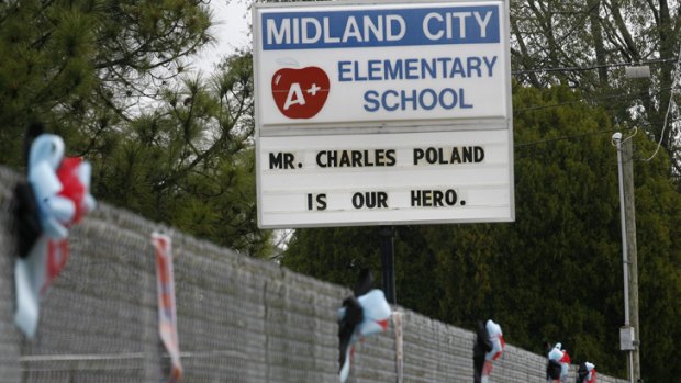 A sign and wreaths honouring murdered bus driver Charles Poland, Jr. at Midland City Elementary School.