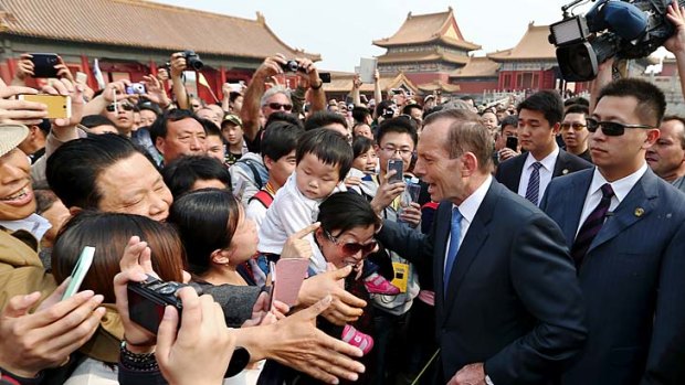 Prime Minister Tony Abbott greets excited tourists during his tour of the Forbidden City in Beijing.