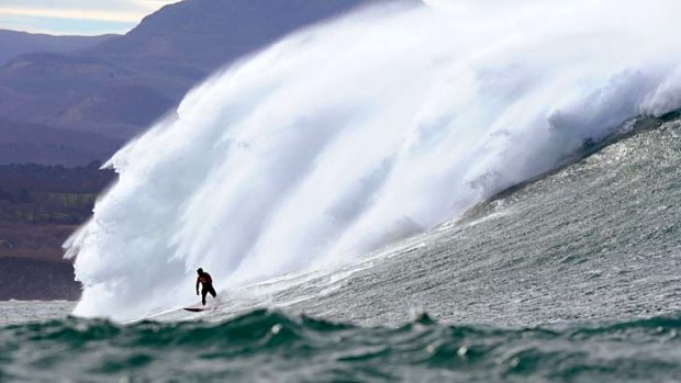 Surfing the Belharra break: a man rides a huge wave.
