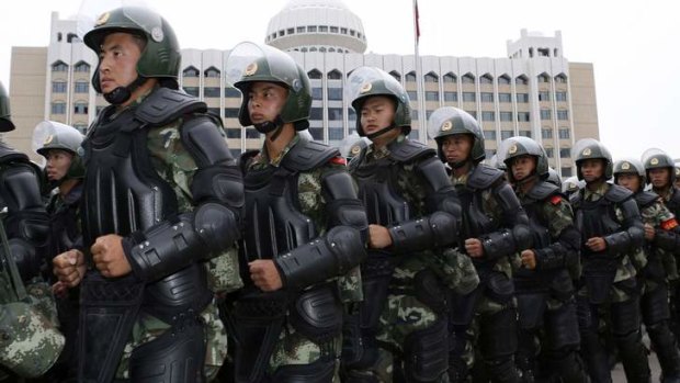 Crackdown: Paramilitary policemen stand in formation during a show of force in Urumqi.