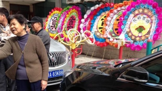 Locals in Urumqi's Gongyuan South Street prepare wreaths for slain relatives.