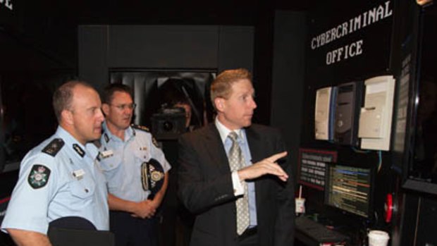 Australian Federal Police (AFP) national manager of high tech crime operations, assistant commissioner Neil Gaughan (L), AFP deputy commissioner Michael Phelan (C), with Symantec vice president and managing director of the Pacific region, Craig Scroggie (R), helping to launch the new public education display called BLK MKT (Black Market).